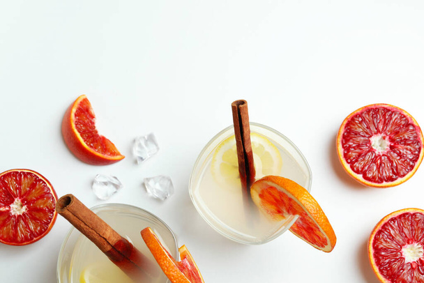 Стаканы коктейля с цитрусовыми на белом фоне - Фото, изображение