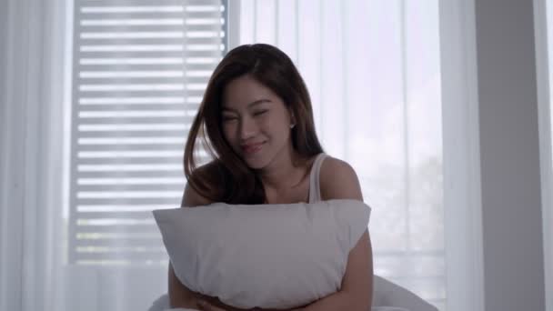 Las mujeres asiáticas se despiertan felices y sonríen en la cama blanca. - Metraje, vídeo