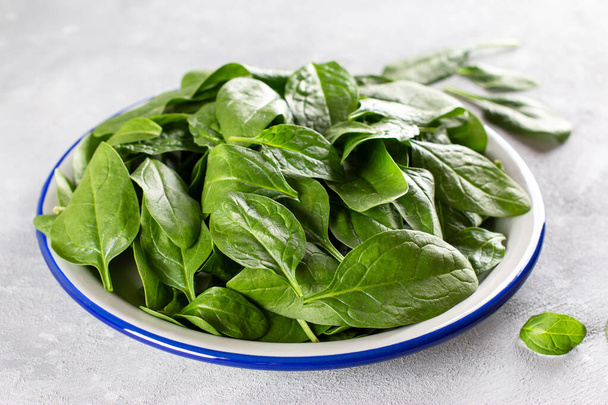 Свежие овощи, зеленый шпинат на тарелке, здоровое питание, вегетарианская концепция питания - Фото, изображение