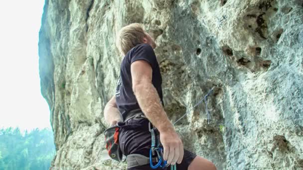 Caucásico en forma hombre escalada en roca, meta logro personal. primer plano, ángulo bajo - Metraje, vídeo