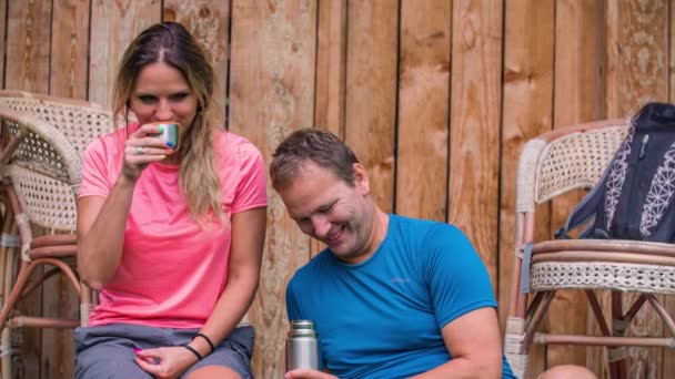 Lähikuva: nuori onnellinen valkoihoinen pari istuu ulkona juomassa kahvia - Materiaali, video