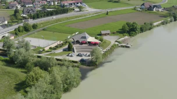 Drone aereo allontanarsi riprese di Caffè bar sul fiume Drava e una strada trafficata - Filmati, video