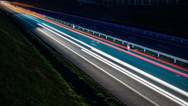 lichten van bewegende auto 's' s nachts. lange blootstelling - Foto, afbeelding