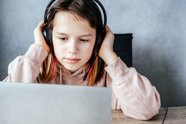 Μια έφηβη κοπέλα που ακούει σε απευθείας σύνδεση μάθημα, e-learning και online εκπαίδευση έννοια - Φωτογραφία, εικόνα