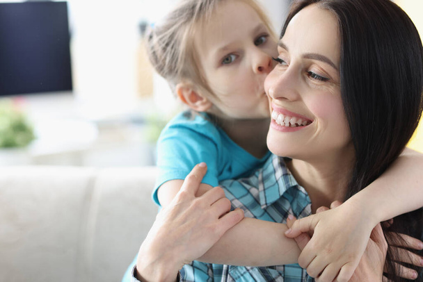 Little girl kissing smiling mom at home - Zdjęcie, obraz