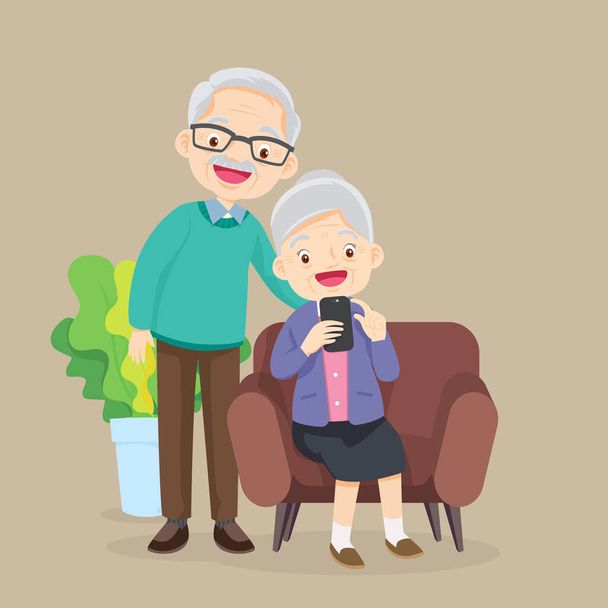 Elderly man and woman sitting on sofa and looks at phone in the living room - Vector, Image