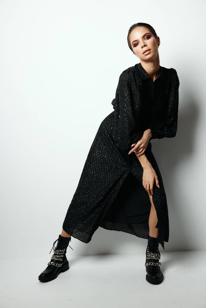 mujer con maquillaje brillante en vestido negro fondo de luz de moda - Foto, imagen