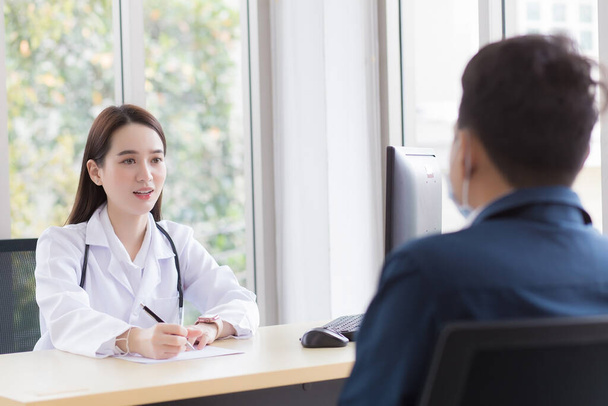 Asiática profesional médico que lleva abrigo médico habla con un hombre paciente para consultar y sugerirle información de salud para él.  - Foto, imagen