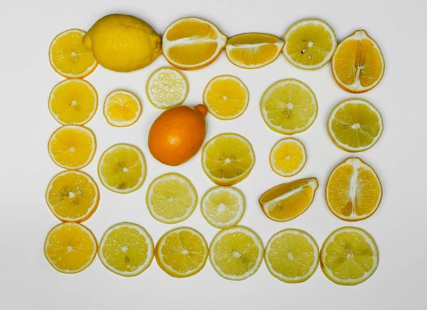 hermoso fondo de diferentes lóbulos de limones y limones enteros sobre un fondo blanco de cerca - Foto, imagen