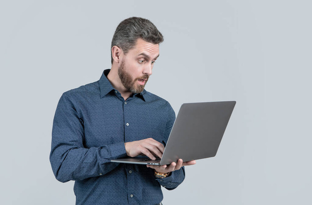 surprised handsome mature man businessman with beard working online on laptop, business. - Photo, Image