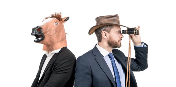 Je regarde au loin. Les hommes professionnels portent une tête de cheval et un chapeau de cow-boy. Des hommes d'affaires bizarres. Soirée costumée. Halloween d'entreprise. C'est tout simplement absurde.. - Photo, image