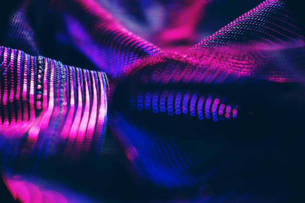 An amazing and beautiful macro of black clothes with pink and blue shine that seems like neon lights in night  - Photo, Image