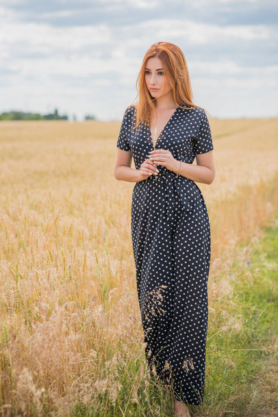 Freedom concept, elegant woman in long black polka dot dress at the field, vintage style for ladies - Fotó, kép