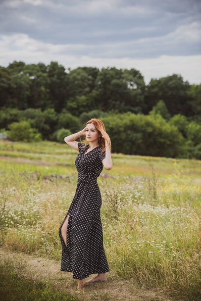 Свобода концепции, элегантная женщина в длинной черной горошек платье на поле, винтажный стиль для женщин - Фото, изображение