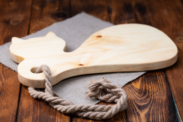Cutting board on a wooden table in the shape of a cat. Handmade chopping board. - Fotoğraf, Görsel
