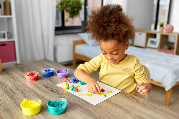 little girl with modeling clay playing at home - Photo, Image