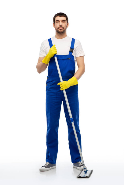 male cleaner in overal cleaning floor with mop - Zdjęcie, obraz
