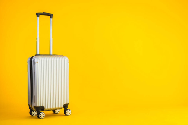 Gray color luggage or baggage bag use for transportation travel and leisure on yellow isolated background - Photo, image