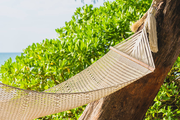Empty hammock on tropical beach sea ocean for leisure relax in vacation travel - Foto, imagen