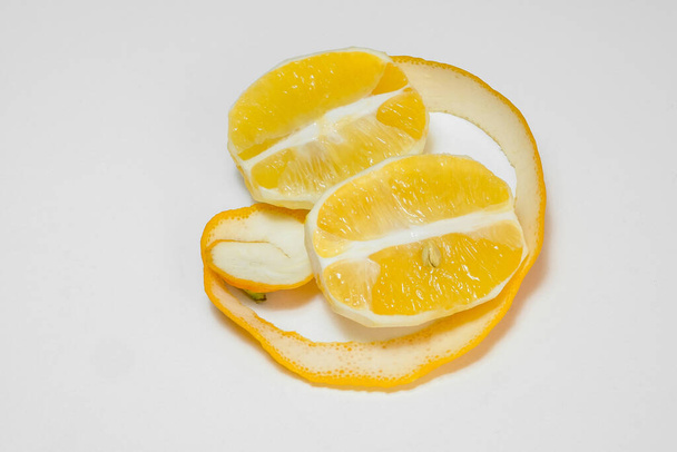 Peeled and cut lemon halves on white background - Photo, Image
