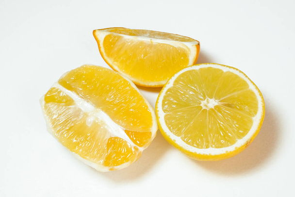 Geschälte und geschnittene Zitronenhälften auf weißem Hintergrund - Foto, Bild