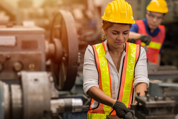 Американские чернокожие женщины-подростки, работающие неполный рабочий день в качестве рабочей силы на промышленном заводе с тяжелой стальной машиной. - Фото, изображение