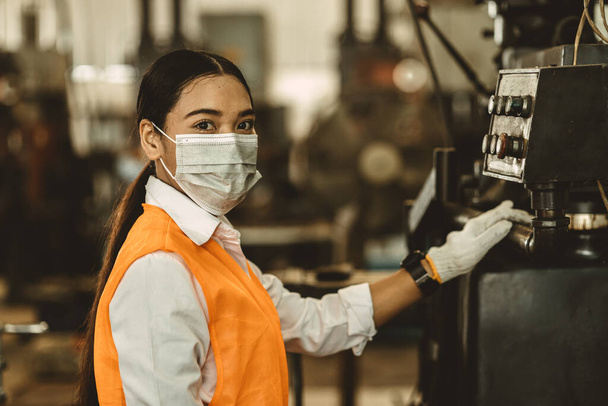 女性労働者保護のための使い捨てフェイスマスクを着用コロナウイルス健康的な労働ケアのために工場で拡散し、ほこりの多い大気汚染フィルターを煙. - 写真・画像