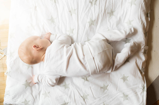 bovenaanzicht van een maand oude baby op deken - Foto, afbeelding
