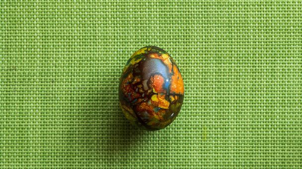 just one very colorful and beautiful Easter egg on a green background - Valokuva, kuva