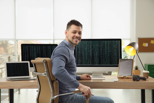 Happy programmer working at desk in office - Photo, Image
