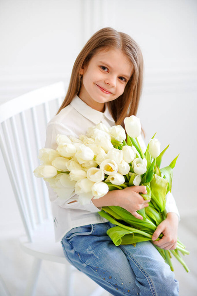 Portrait of beautiful pretty girl with white flowers tulips sitt - Foto, Imagen