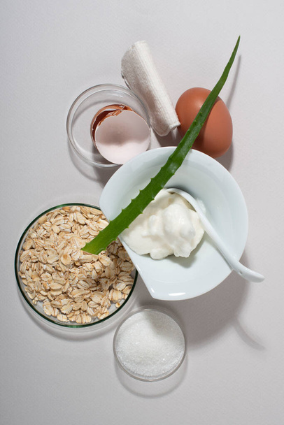 Yumurta beyazı maske malzemeleri. Krem şantili yumurta, aloe şekeri, yulaf ezmesi. Kapat.. - Fotoğraf, Görsel