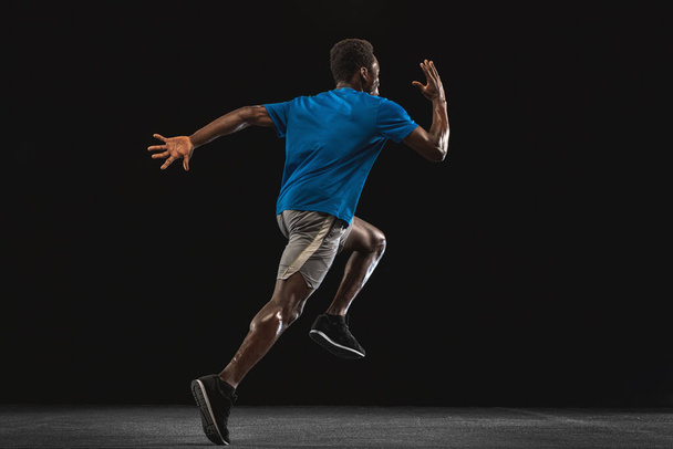 One African-American man, athlete training isolated over black background. - Photo, Image