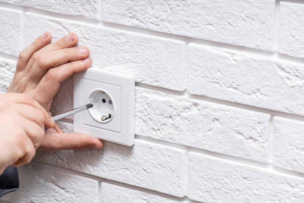 Electrician mounting electric sockets on the white wall indoors - Foto, Imagem