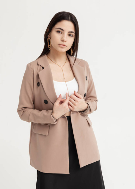 beautiful brunette in a jacket and summer clothes on a light background - Fotó, kép