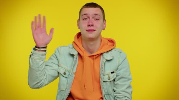Man tiener glimlachend vriendelijk op camera en zwaaiende handen gebaren hallo of vaarwel, verwelkomen - Video