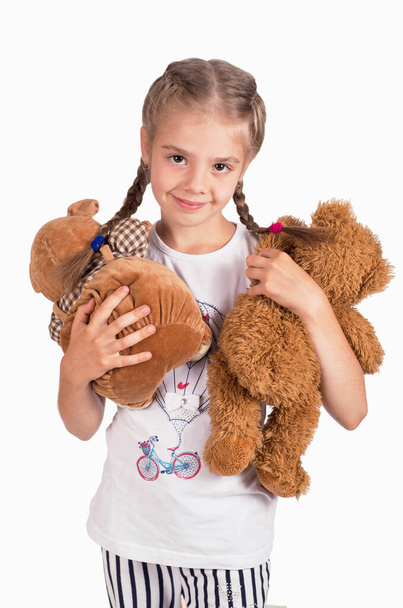Little girl holding a teddy bear. Isolated on white background. Girl hugging two teddybears. Happy child. - Foto, afbeelding