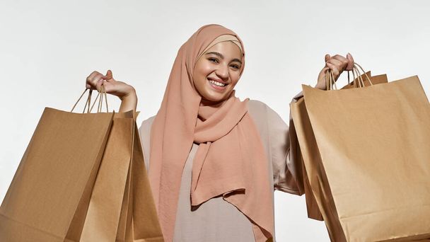 Portrait of happy young arabian girl holding packets - Zdjęcie, obraz
