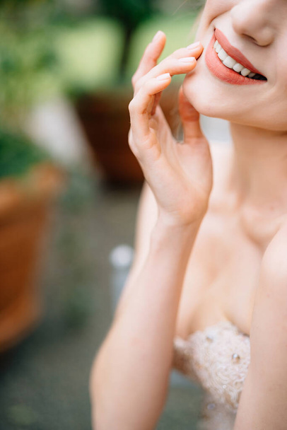 Mariée souriante dans une belle robe mettre sa main sur son menton - Photo, image