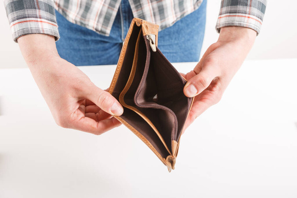 Empty wallet in the hands of an elderly man. Poverty in retirement concept - Foto, Imagen