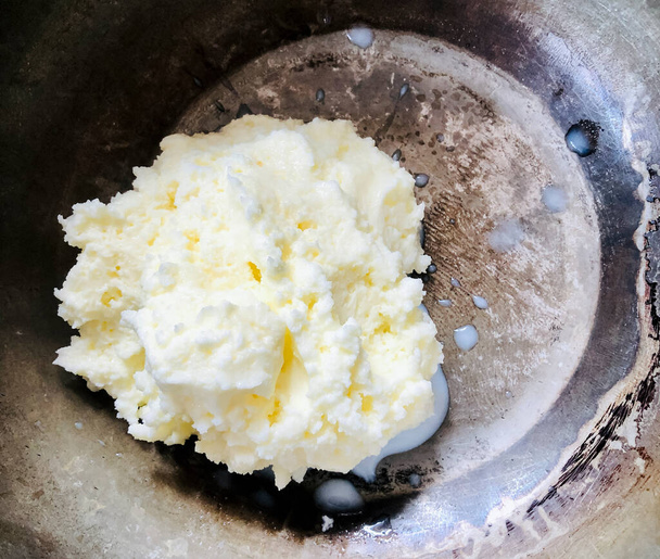 En el Nepal rural, la mantequilla se hace solo con yogur, se agrega agua al yogur natural casero y se mezcla durante 10 a 15 minutos para amoladora mezcladora. Verás primero burbujas de mantequilla y luego los racimos de mantequilla en la superficie de ayran. cuando hueles y saboreas  - Foto, Imagen