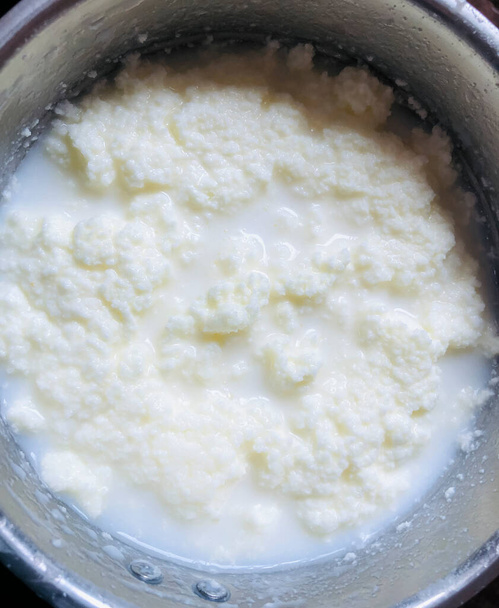 En el Nepal rural, la mantequilla se hace solo con yogur, se agrega agua al yogur natural casero y se mezcla durante 10 a 15 minutos para amoladora mezcladora. Verás primero burbujas de mantequilla y luego los racimos de mantequilla en la superficie de ayran. cuando hueles y saboreas  - Foto, Imagen