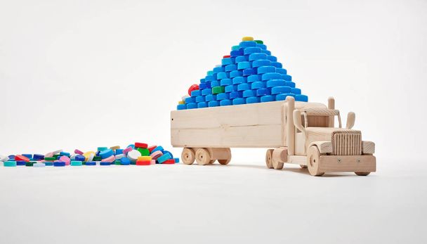 Wooden truck carries plastic caps. Plastic city concept. Plastic-free concept. Low Co2 Emission Transport Concept. - Photo, Image