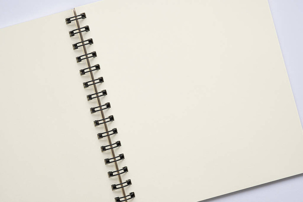 Vista dall'alto, aprire il notebook a spirale vuoto su sfondo bianco, copiare lo spazio per il testo. - Foto, immagini