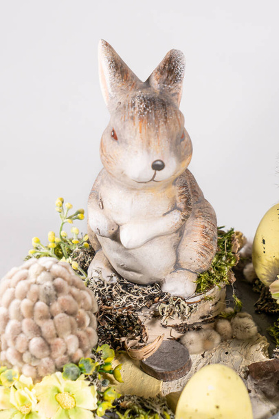Composición de mesa de Pascua con conejos y huevos de Pascua, en el fondo blanco las flores de narciso amarillo en macetas tejidas blancas. Conejo de Pascua con decoraciones florales - Foto, Imagen