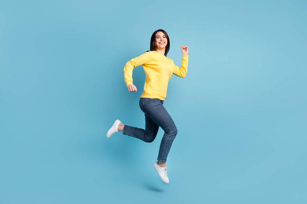 Full size photo of nice optimistic brunette long hairdo lady run wear shirt jeans sneakers isolated on blue color background - 写真・画像
