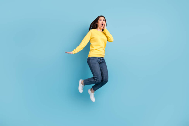 Full size photo of nice stressed brunette long hairdo lady jump wear shirt jeans sneakers isolated on blue color background - Φωτογραφία, εικόνα