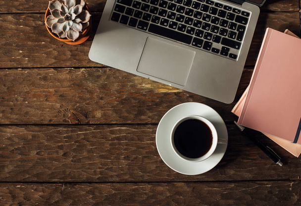 верхний вид чашки кофе и ноутбука на деревянный стол - Фото, изображение