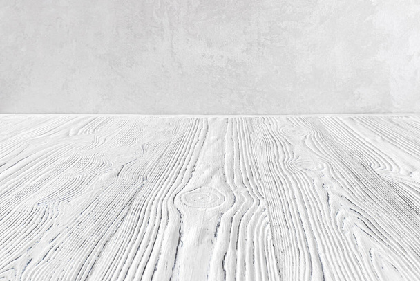 Prázdný bílý dřevěný povrch proti šedé dekorativní omítky nebo betonové pozadí. Mockup pro design. - Fotografie, Obrázek