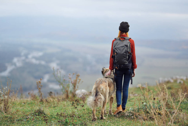 nainen retkeilijä reppu koiran kanssa vuorilla matkustaa ystävyys - Valokuva, kuva